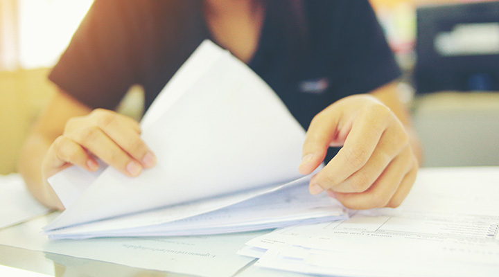 image of woman's hands as she goes through tax paperwork
